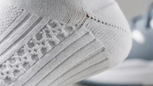 Détail technique d'une chaussette de tennis avec zones de compression et matériaux anti-friction